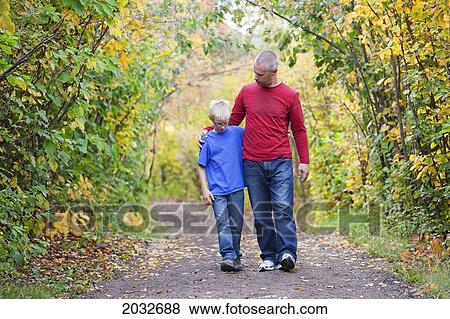 Stock Photo - Father And Son Walking On A Path In A Park In Autumn; Edmonton Alberta Canada. Fotosearch