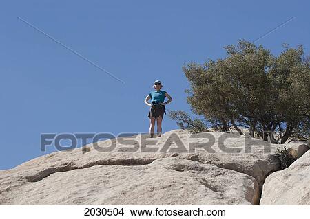 Female Hiker On Top Of Large Rounded Rock With Desert Shrub And Blue Sky; Palm Springs California United States Of America View Large Photo Image Picture - Female Hiker On Top Of Large Rounded Rock With Desert Shrub And Blue Sky; Palm Springs California United States Of America. Fotosearch