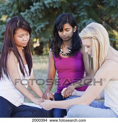 Picture - Friends Holding Hands And Praying Together; Edmonton Alberta Canada. Fotosearch