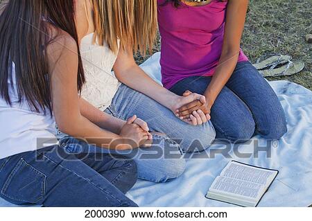 Stock Image - Friends Holding Hands And Praying Together; Edmonton Alberta Canada. Fotosearch