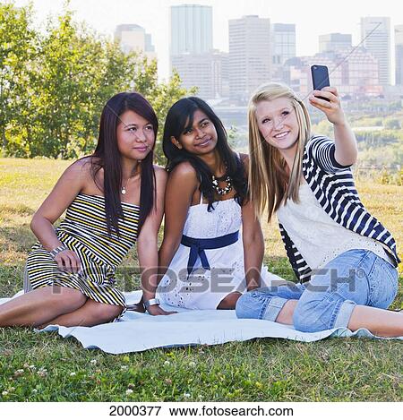 Stock Photo - Friends Taking A Picture In A City Park With The City Skyline In The Background; Edmonton Alberta Canada. Fotosearch