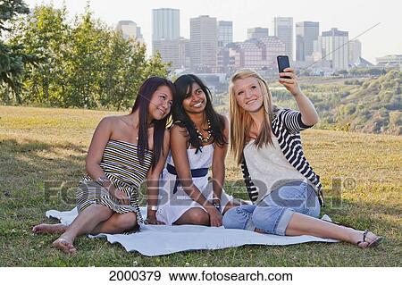 Friends Taking A Picture In A City Park With The City Skyline In The Background; Edmonton Alberta Canada View Large Photo Image Stock Photo - Friends Taking A Picture In A City Park With The City Skyline In The Background; Edmonton Alberta Canada. Fotosearch