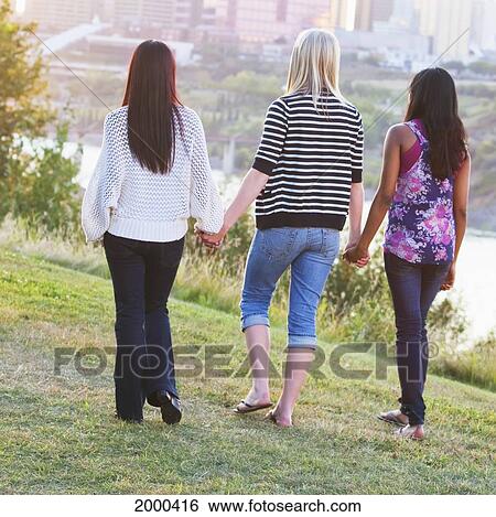 Friends Walking In A City Park At Dusk With The City Skyline In The Background; Edmonton Alberta Canada View Large Photo Image Stock Photograph - Friends Walking In A City Park At Dusk With The City Skyline In The Background; Edmonton Alberta Canada. Fotosearch