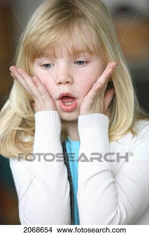 Picture - Girl With Blond Hair Holding Face With Hands In A Look Of Shock; Troutdale Oregon United States Of America. Fotosearch