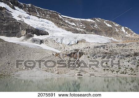 Glacier On Mountain Side Streaming Down Into A Reflective Mountain Pond With Blue Sky; Field British Columbia Canada View Large Photo Image Stock Image - Glacier On Mountain Side Streaming Down Into A Reflective Mountain Pond With Blue Sky; Field British Columbia Canada. Fotosearch