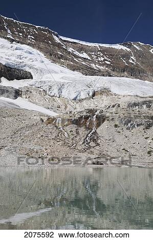 Glacier On Mountain Side Streaming Down Into A Reflective Mountain Pond With Blue Sky; Field British Columbia Canada View Large Photo Image Stock Image - Glacier On Mountain Side Streaming Down Into A Reflective Mountain Pond With Blue Sky; Field British Columbia Canada. Fotosearch