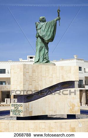 Stock Photo - Green Statue Of A Male Figure Holding A Cross; Lagos Algarve Portugal. Fotosearch