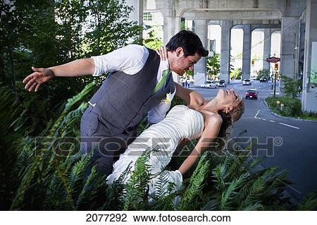 Groom dipping a bride along the side of a road under an urban bridge; vancouver british columbia canada View Large Photo Image Stock Image - Groom dipping a bride along the side of a road under an urban bridge; vancouver british columbia canada. Fotosearch