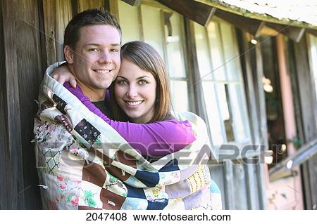 Stock Photo - Guy And Girl Snuggled Up In A Patchwork Blanket; Troutdale Oregon United States Of America. Fotosearch