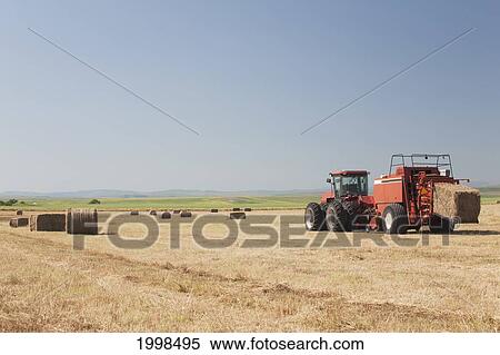 Hay Baler In A Field With Blue Sky; Alberta Canada View Large Photo Image Stock Photography - Hay Baler In A Field With Blue Sky; Alberta Canada. Fotosearch