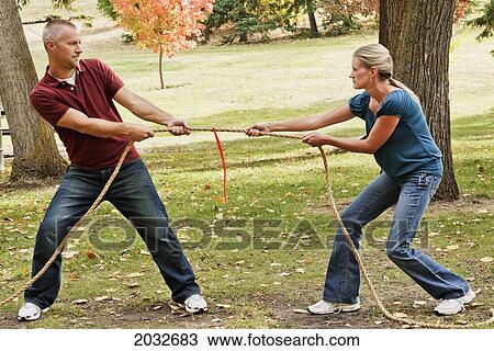 Husband And Wife Playing Tug Of War In A Park; Edmonton Alberta Canada View Large Photo Image Stock Image - Husband And Wife Playing Tug Of War In A Park; Edmonton Alberta Canada. Fotosearch