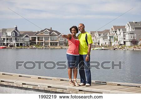 Husband And Wife Standing On A Pier And Looking At A Residential Lake Neighborhood; Edmonton Alberta Canada View Large Photo Image Stock Photo - Husband And Wife Standing On A Pier And Looking At A Residential Lake Neighborhood; Edmonton Alberta Canada. Fotosearch