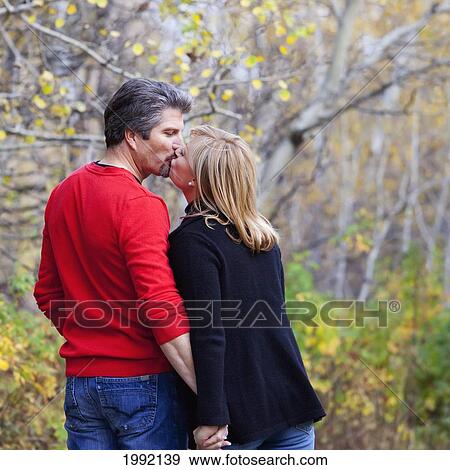 Husband And Wife Walking And Kissing In A Park In Autumn; St. Albert Alberta Canada View Large Photo Image Stock Photo - Husband And Wife Walking And Kissing In A Park In Autumn; St. Albert Alberta Canada. Fotosearch