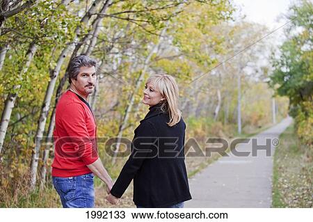 Stock Image - Husband And Wife Walking In A Park In Autumn; St. Albert Alberta Canada. Fotosearch