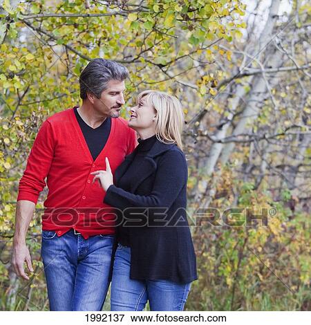 Stock Photo - Husband And Wife Walking In A Park In Autumn; St. Albert Alberta Canada. Fotosearch