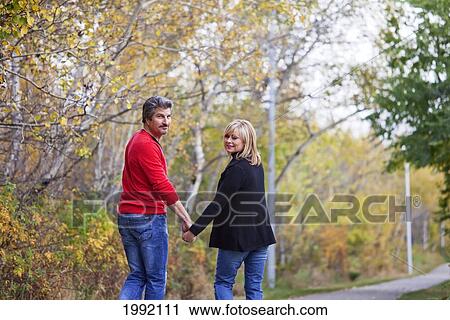 Husband And Wife Walking In The Park During Autumn; St. Albert Alberta Canada View Large Photo Image Stock Image - Husband And Wife Walking In The Park During Autumn; St. Albert Alberta Canada. Fotosearch