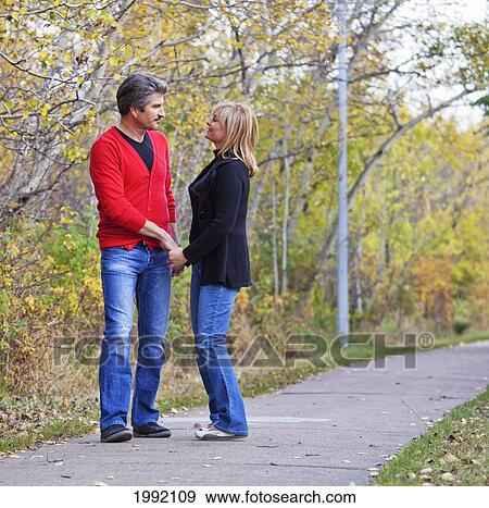 Husband And Wife Walking In The Park During Autumn; St. Albert Alberta Canada View Large Photo Image Stock Photo - Husband And Wife Walking In The Park During Autumn; St. Albert Alberta Canada. Fotosearch