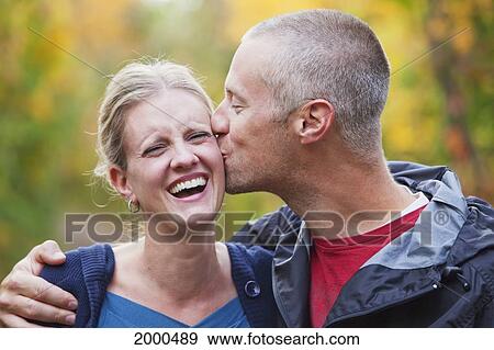 Husband Gives Wife A Kiss On The Cheek While Walking Down A Park Path In Autumn; Edmonton Alberta Canada View Large Photo Image Stock Photo - Husband Gives Wife A Kiss On The Cheek While Walking Down A Park Path In Autumn; Edmonton Alberta Canada. Fotosearch