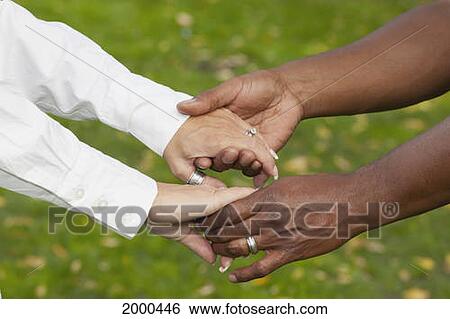 Stock Photograph - Inter-Racial Couple Holding Hands; Edmonton Alberta Canada. Fotosearch