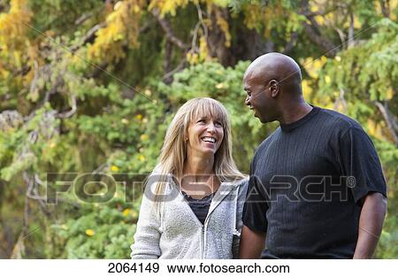 Interracial Couple Walking In A Park In Autumn; Edmonton Alberta Canada View Large Photo Image Stock Photo - Interracial Couple Walking In A Park In Autumn; Edmonton Alberta Canada. Fotosearch