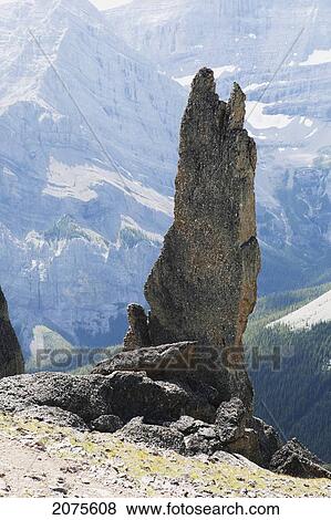 Large Rock Sentinel On Mountain Ridge With A Mountain Range In The Distance; Alberta Canada View Large Photo Image Stock Photo - Large Rock Sentinel On Mountain Ridge With A Mountain Range In The Distance; Alberta Canada. Fotosearch