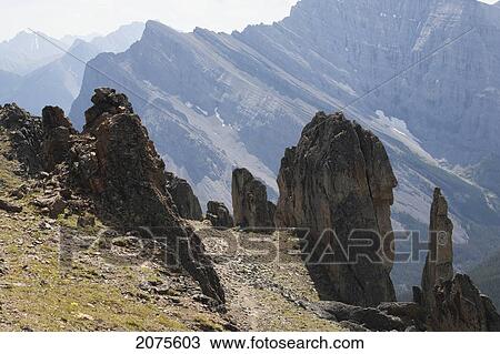Large Rock Sentinels On Mountain Ridge With A Mountain Range In The Distance; Alberta Canada View Large Photo Image Stock Image - Large Rock Sentinels On Mountain Ridge With A Mountain Range In The Distance; Alberta Canada. Fotosearch
