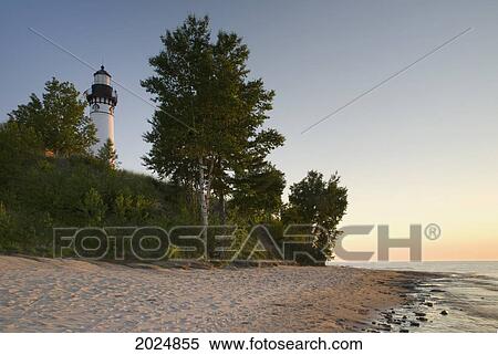 Stock Photography - Lighthouse At Sunset Seen From The Beach; Michigan United States Of America. Fotosearch