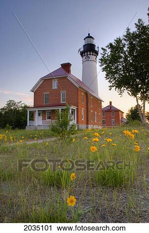 Stock Image - Lighthouse With Yellow Flower In The Foreground; Michigan United States Of America. Fotosearch