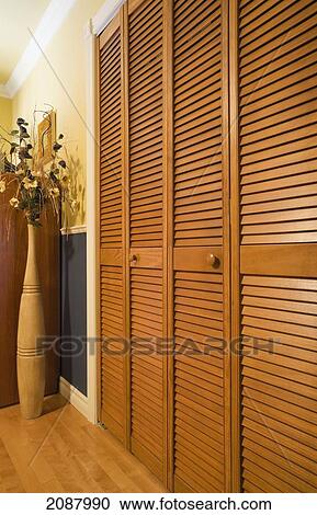 Louvered Panelled Wooden Closet Doors In A Bedroom Quebec Canada Stock Image