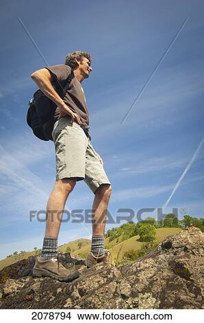 Man standing on a rock with a backpack; sutter buttes california united states of america View Large Photo Image Picture - Man standing on a rock with a backpack; sutter buttes california united states of america. Fotosearch