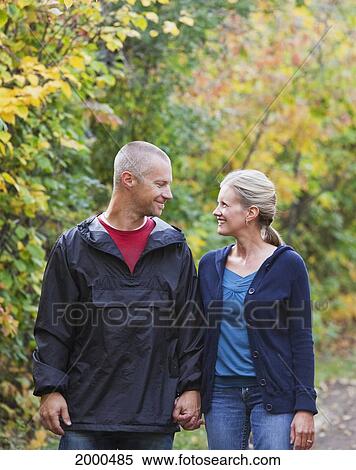 Stock Photography - Married Couple Walking And Talking On A Park Path In Autumn; Edmonton Alberta Canada. Fotosearch