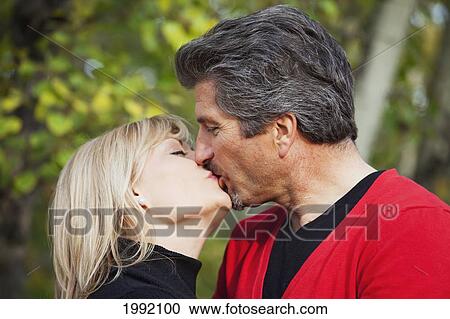 Stock Image - Mature Couple Kissing; St. Albert Alberta Canada. Fotosearch