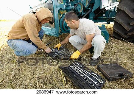 Men going through tools to repair farm equipment; three hills alberta canada View Large Photo Image Stock Photo - Men going through tools to repair farm equipment; three hills alberta canada. Fotosearch