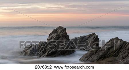 Mist surrounding rocks in the ocean at the coast at sunset; sayulita mexico View Large Photo Image Stock Image - Mist surrounding rocks in the ocean at the coast at sunset; sayulita mexico. Fotosearch
