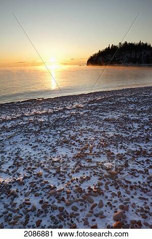 Misty sunrise over lake superior with a trace of snow on the rocky beach; thunder bay ontario canada View Large Photo Image Stock Image - Misty sunrise over lake superior with a trace of snow on the rocky beach; thunder bay ontario canada. Fotosearch