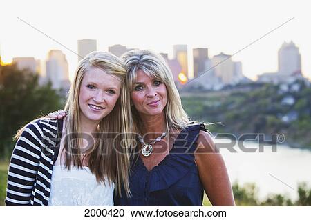Stock Image - Mother And Daughter In A Park Together With The City Skyline In The Background; Edmonton Alberta Canada. Fotosearch