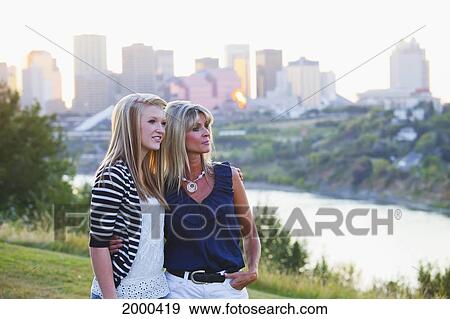 Stock Photo - Mother And Daughter In A Park Together With The City Skyline In The Background; Edmonton Alberta Canada. Fotosearch