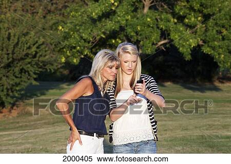 Mother And Daughter Walking In A Park And Sharing Text Messages Together; Edmonton Alberta Canada View Large Photo Image Stock Photography - Mother And Daughter Walking In A Park And Sharing Text Messages Together; Edmonton Alberta Canada. Fotosearch