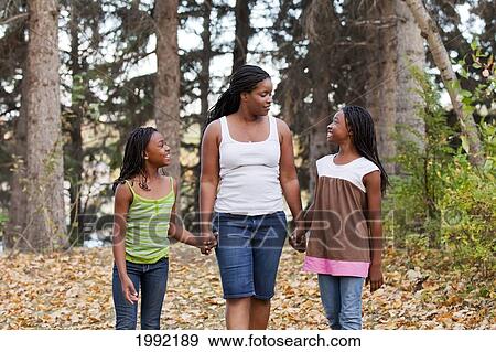 Stock Photo - Mother And Two Daughters Walking In A Park; Edmonton Alberta Canada. Fotosearch