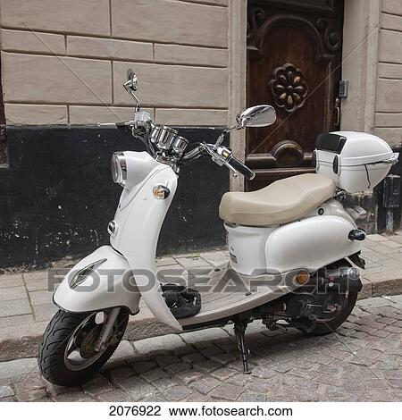 Stock Image - Motor scooter parked outside a building in old town; stockholm sweden. Fotosearch