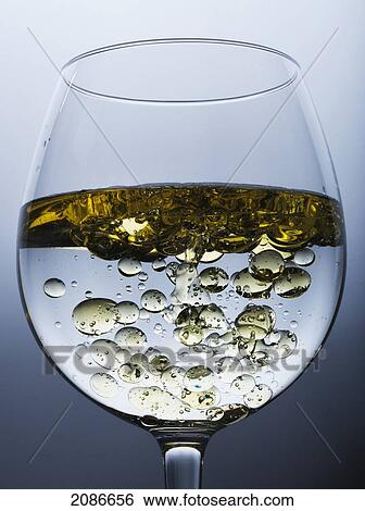 Stock Photograph - Oil poured into water in a glass; tarifa cadiz andalusia spain. Fotosearch