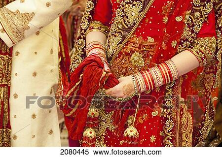 Stock Photography - Ornate robes and jewelry worn by the bride and groom on a wedding day in india; ludhiana punjab india. Fotosearch