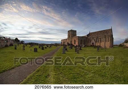 Stock Photography - Path leading to a church building and cemetery; bamburgh northumberland england. Fotosearch