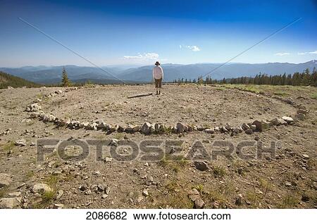 Stock Image - Person standing in a circle of stones mount shasta; california united states of america. Fotosearch