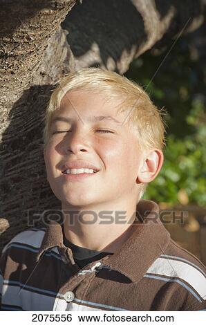 Portrait Of A Boy With Blond Hair Outside Under A Tree With Eyes Closed; Moraga California United States Of America View Large Photo Image Stock Photograph - Portrait Of A Boy With Blond Hair Outside Under A Tree With Eyes Closed; Moraga California United States Of America. Fotosearch