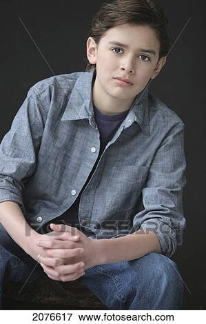 Portrait of a boy with brown hair and brown eyes wearing a denim shirt with hands clasped; troutdale oregon united states of america View Large Photo Image Stock Photo - Portrait of a boy with brown hair and brown eyes wearing a denim shirt with hands clasped; troutdale oregon united states of america. Fotosearch
