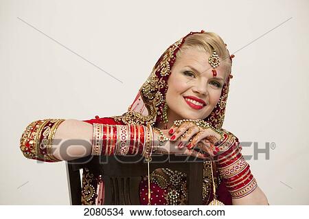 Portrait of a bride with blond hair wearing a red and gold sari and jewelry; ludhiana punjab india View Large Photo Image Picture - Portrait of a bride with blond hair wearing a red and gold sari and jewelry; ludhiana punjab india. Fotosearch