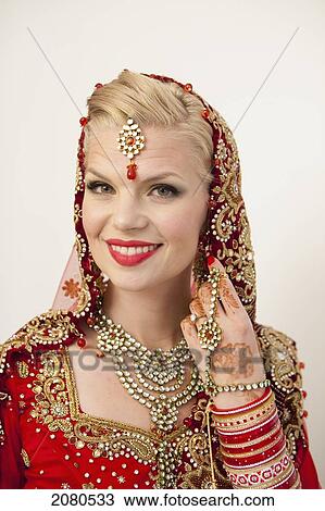 Portrait of a bride with blond hair wearing a red and gold sari; ludhiana punjab india View Large Photo Image Stock Image - Portrait of a bride with blond hair wearing a red and gold sari; ludhiana punjab india. Fotosearch