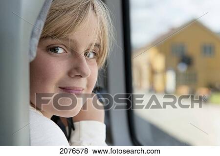Stock Photo - Portrait of a girl sitting by the window; highlands norway. Fotosearch