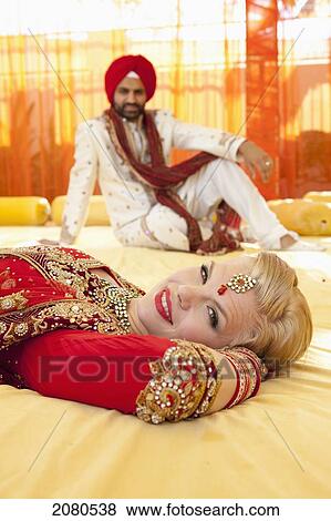 Portrait of a mixed race couple on their wedding day in traditional indian garments for a wedding; ludhiana punjab india View Large Photo Image Stock Photo - Portrait of a mixed race couple on their wedding day in traditional indian garments for a wedding; ludhiana punjab india. Fotosearch